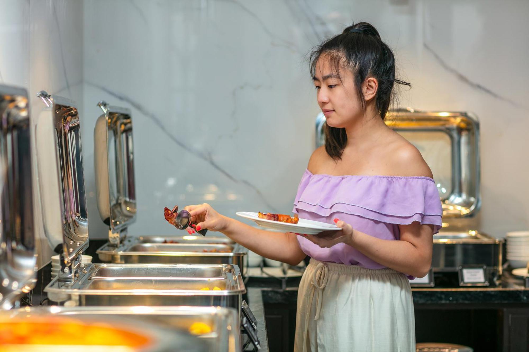 เมย์ เดอ วิลล์ ลักชัวรี โฮเทล แอนด์ สปา Hotel ฮานอย ภายนอก รูปภาพ A woman serving herself at a buffet